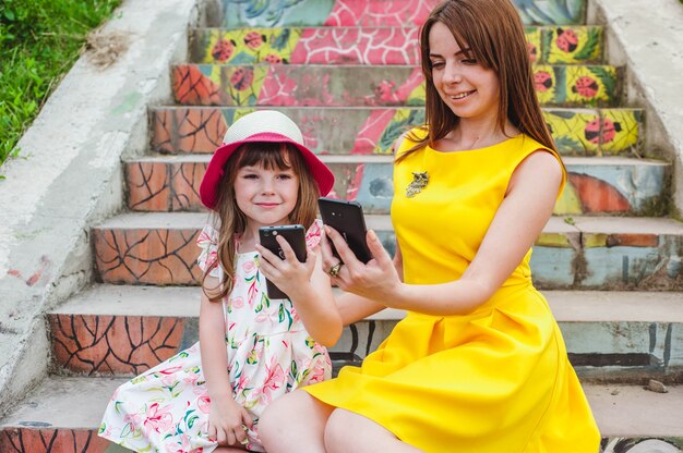 Mother and daughter each looking at her mobile phone