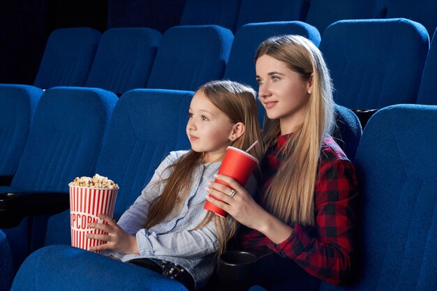 映画館で映画を楽しんでいる母と娘。