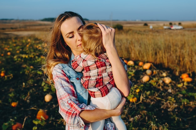 Mother and daughter on a field with pumpkins