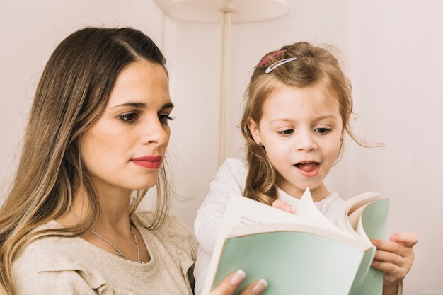 Mother and daughter flipping pages of book