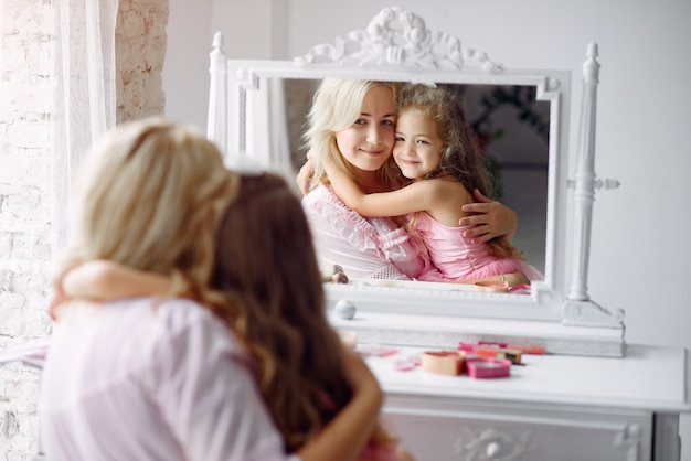 Mother and daughter gather in the morning in front of a mirror
