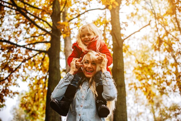 Mother and daughter having fun in autumn park
