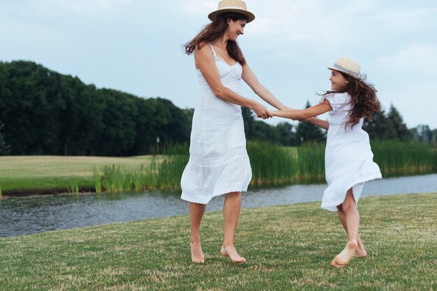 Mother and daughter having fun by the lake