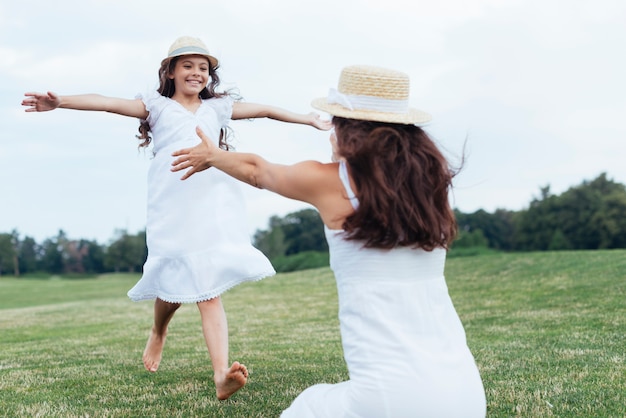 Free photo mother and daughter having fun by the lake