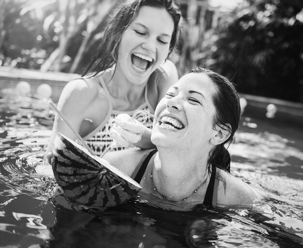 Мать и дочь веселятся в бассейне