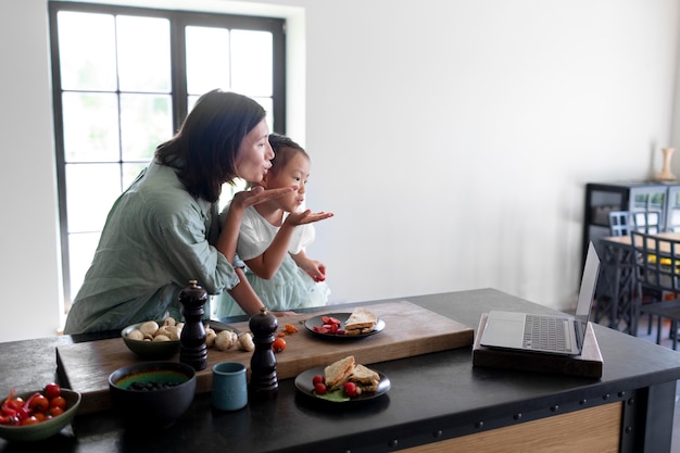 Madre e figlia fanno una videochiamata dalla loro cucina