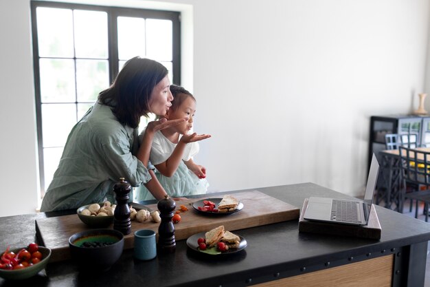 Mother and daughter having a video call from their kitchen