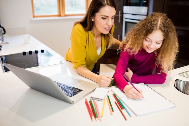 Mother and daughter helping daughter with her homework