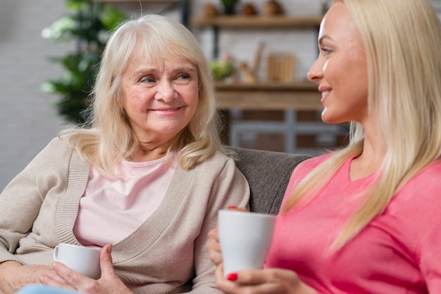 Mother and daughter holding cups of coffee