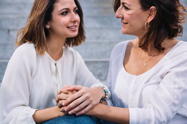 Mother and daughter holding hands and looking at each other