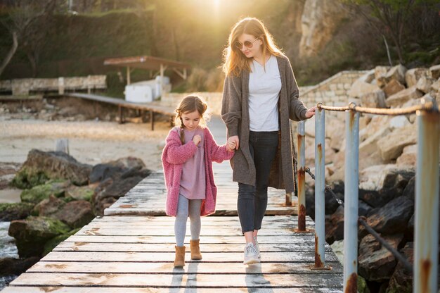 Mother and daughter holding hands outdoors