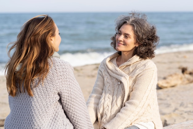 Mother and daughter holding hands together at the beach