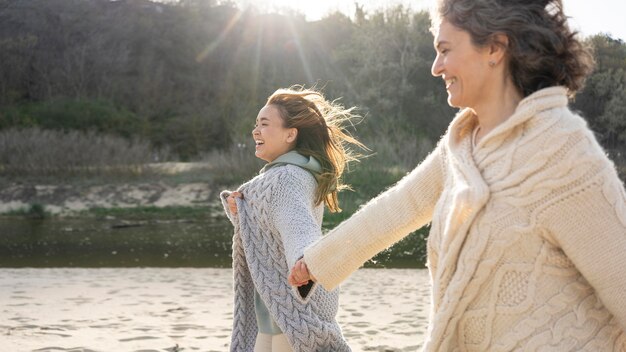 Mother and daughter holding hands together at the beach