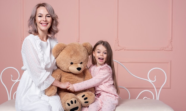 Free photo mother and daughter holding teddy bear