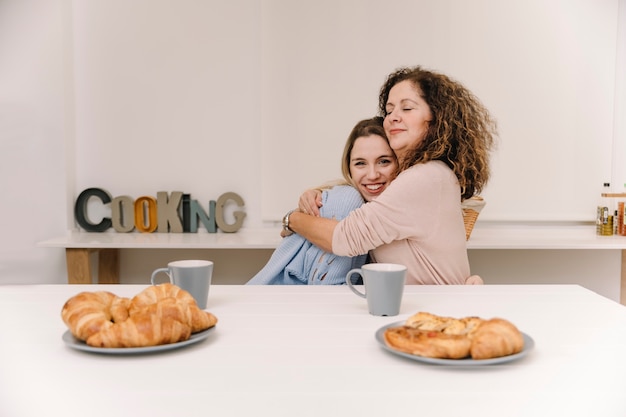 Mother and daughter hugging during breakfast