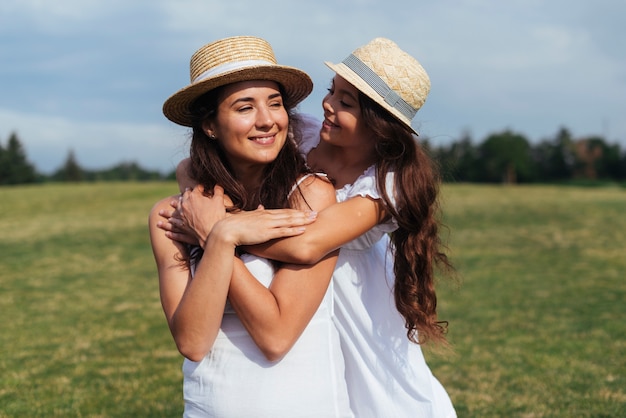 Mother and daughter hugging outdoors