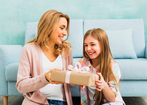 Mother and daughter laughing and holding present box