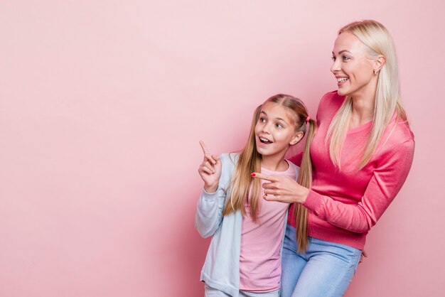 Mother and daughter looking away and copy space background