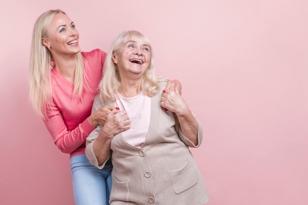 Mother and daughter looking away and copy space background