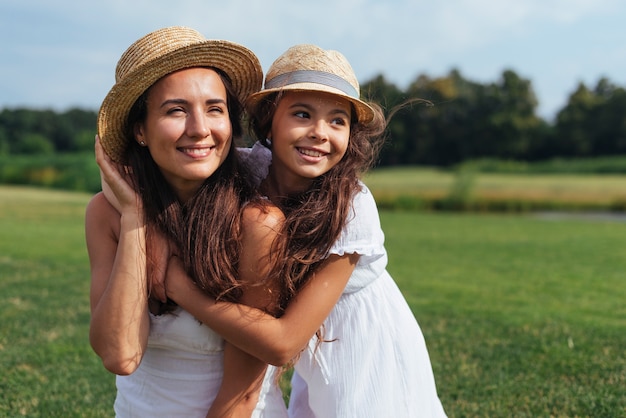 Madre e figlia che distolgono lo sguardo in natura