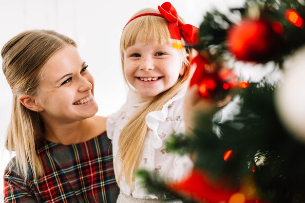 Mother and daughter looking at christmas tree
