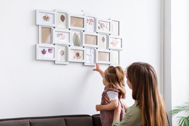 Free photo mother and daughter looking at frame