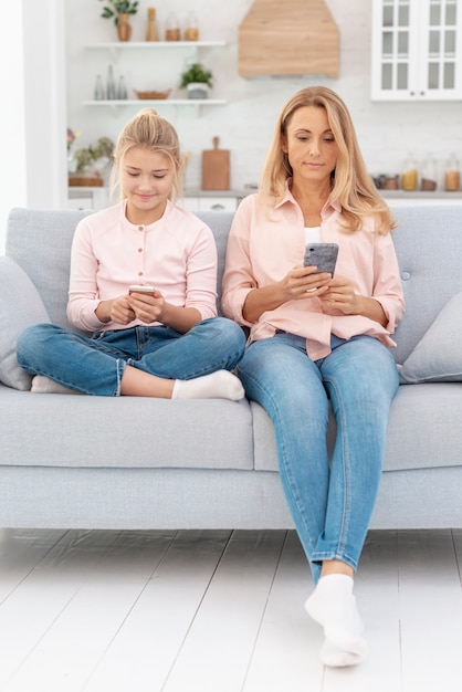 Mother and daughter looking on phones