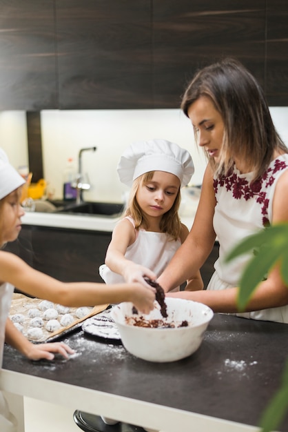 Mother and daughter making cookies in kitchen