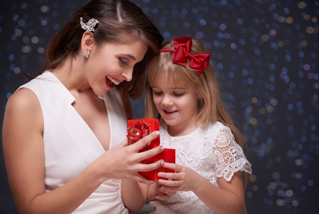 Mother and daughter opening present together