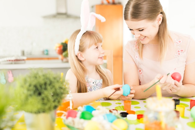 Mother and daughter painting eggs