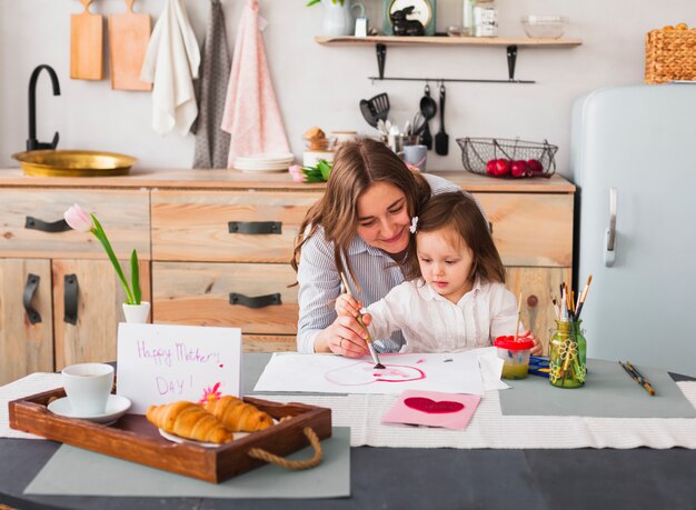 Foto gratuita madre e figlia pittura cuore a tavola