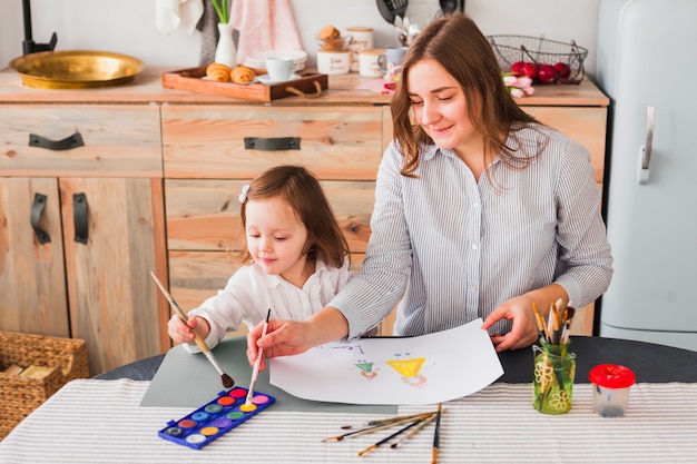 Mother and daughter painting on paper