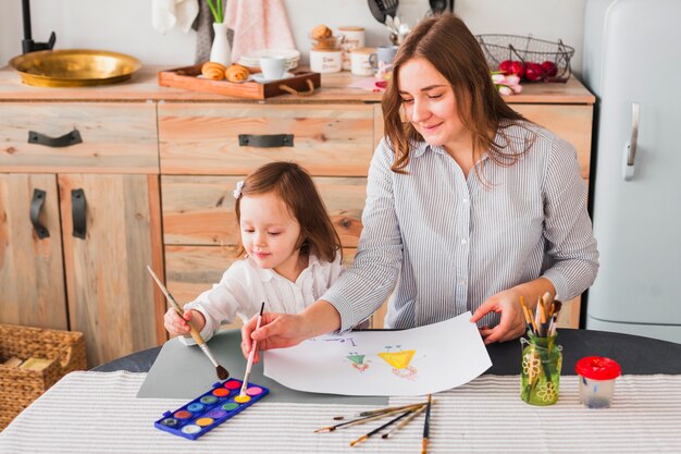 Mother and daughter painting on paper