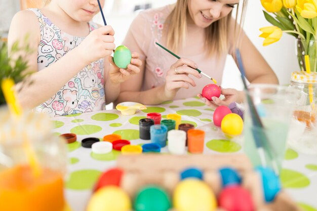 Mother and daughter painting traditional eggs