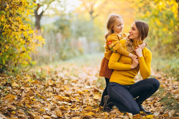 Mother and daughter in park full of leaves