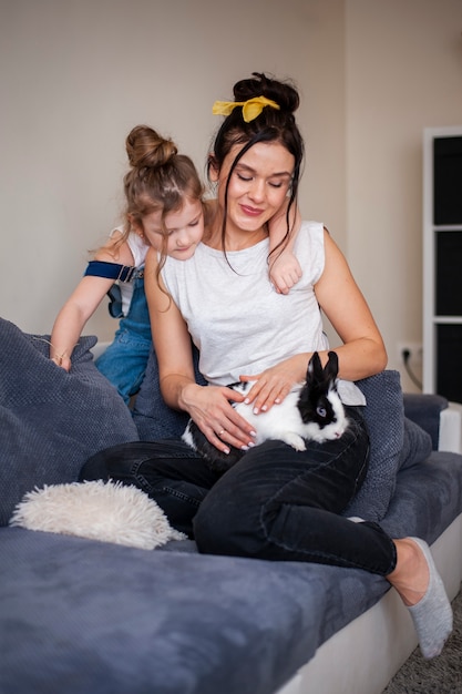 Free photo mother and daughter petting adorable rabbit