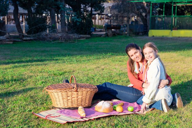 Mother and daughter picnicking in the park