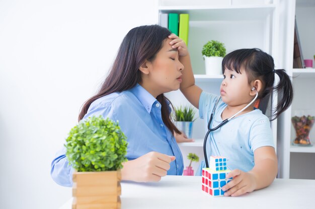 Mother and daughter playing doctor with stethoscope