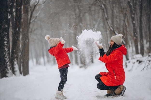 Mother and daughter playing in winter park