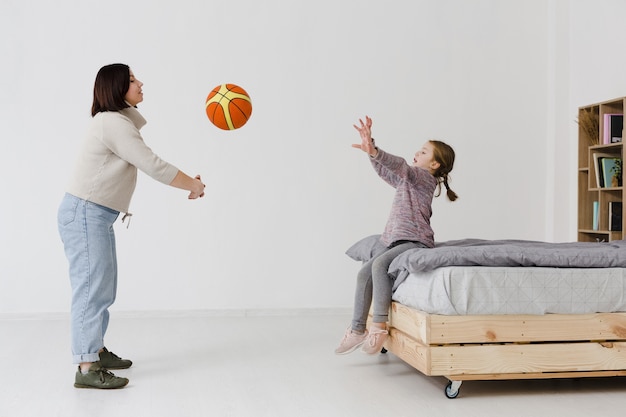 Mother and daughter playing with basketball