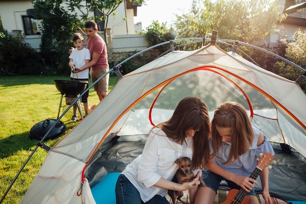 Madre e figlia che giocano con il loro animale domestico in tenda