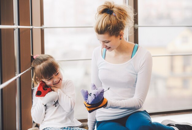 Madre e figlia che giocano con i giocattoli in palestra