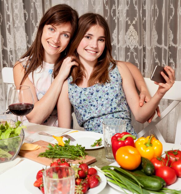 Mother and daughter posing at dinner table