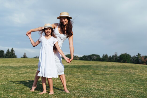 Mother and daughter posing outdoors