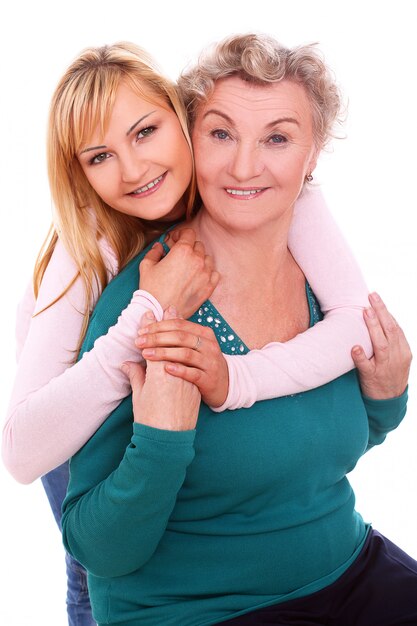 mother and daughter posing on white