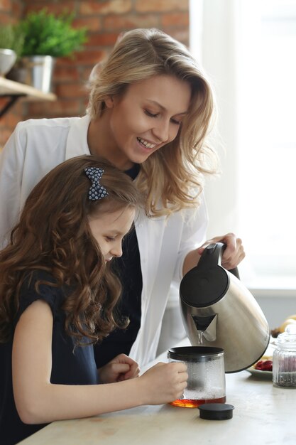 Мать и дочь готовят кофе или чай