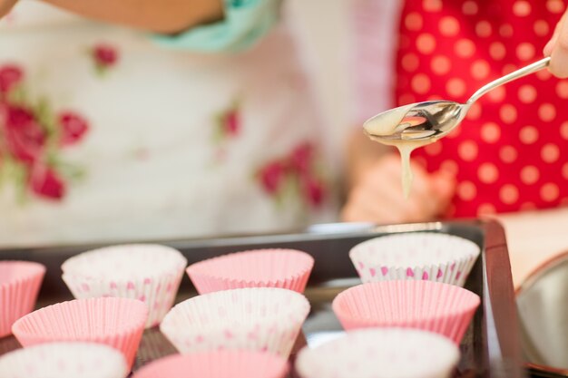Mother and daughter preparing cupcake in kitchen