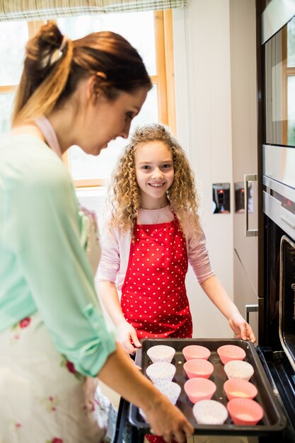 Мать и дочь приготовления кекс на кухне