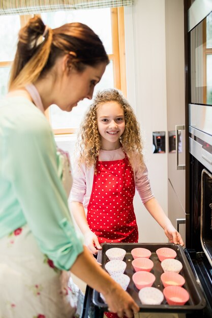 Mother and daughter preparing cupcake in kitchen