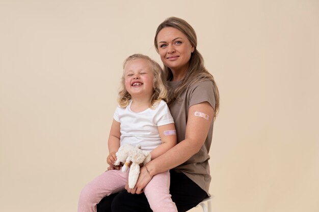 Mother and daughter showing sticker on arm after getting a vaccine